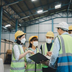 Group of working staff having safety meeting at factory